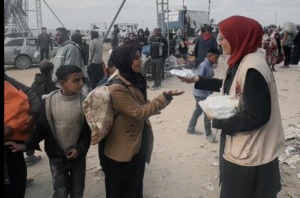 فتاة من فريق سواعد فلسطين توزع الفطور على الصائميين في غزة
